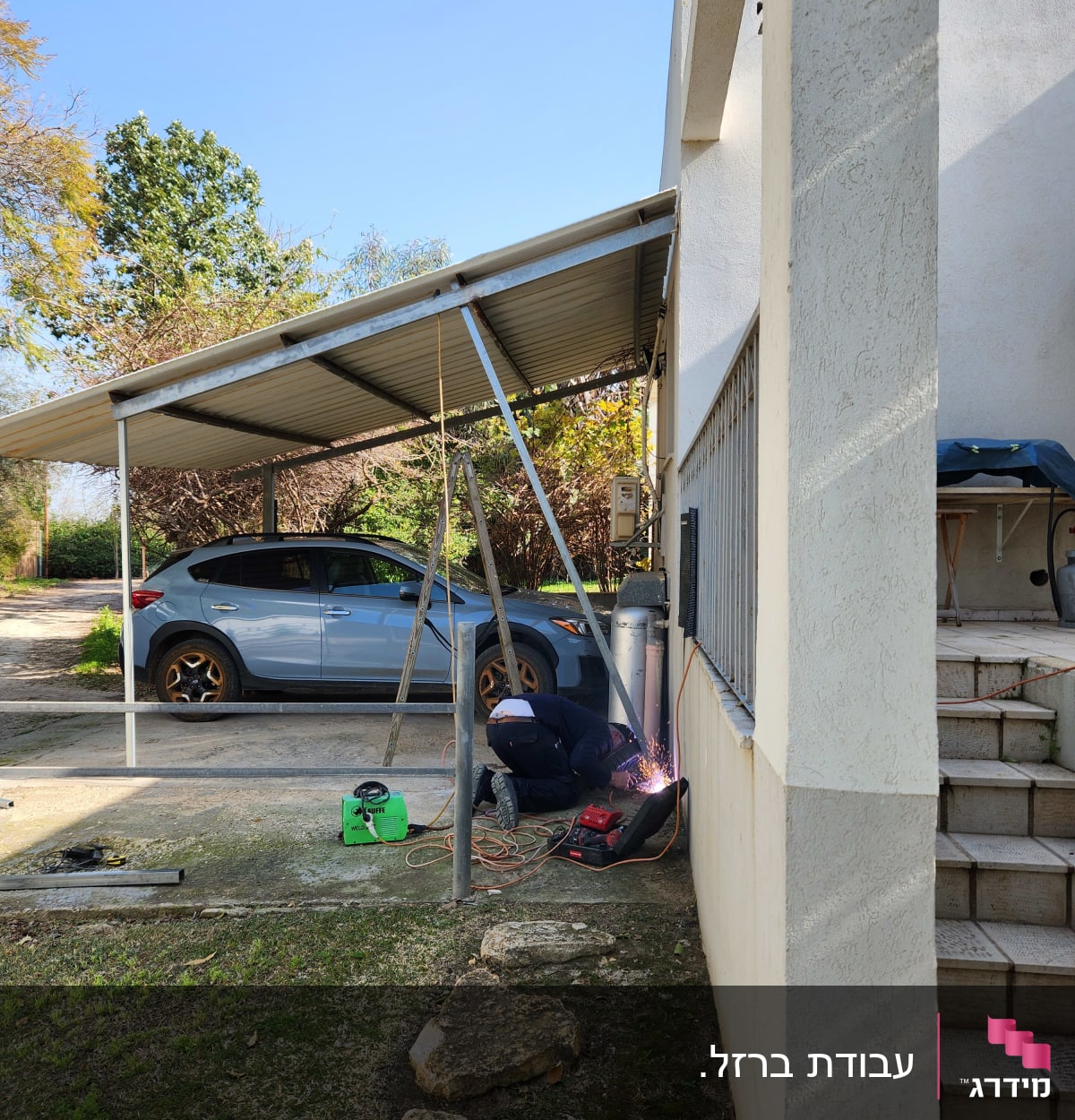 אדם מרתך מסגרת מתכת ליד קיר חיצוני